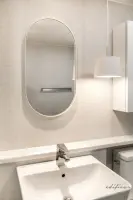 테라조 타일과 오벌 거울의 미니멀 세면대